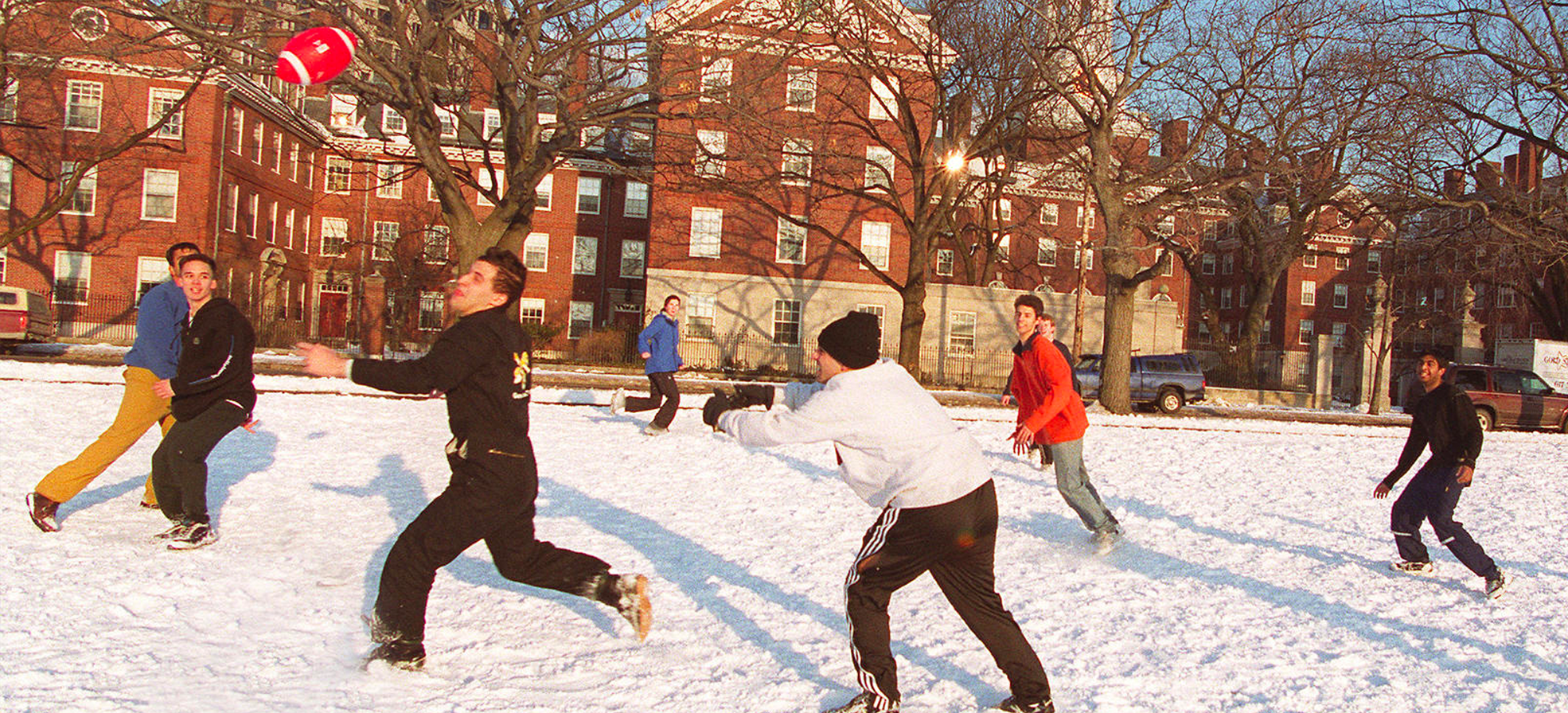 students playing football in the snow