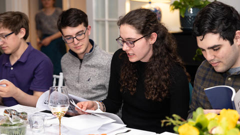 Students read a passage prior to passover seder at the Dean of Students' residence.