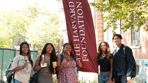 6 students in front of Harvard Foundation banner.