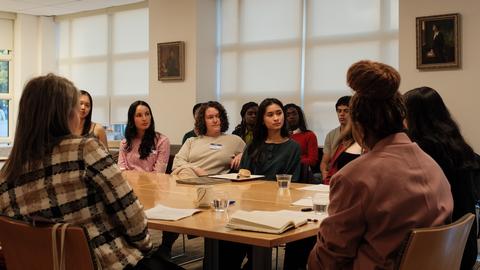 students and staff in discussion with panelist.