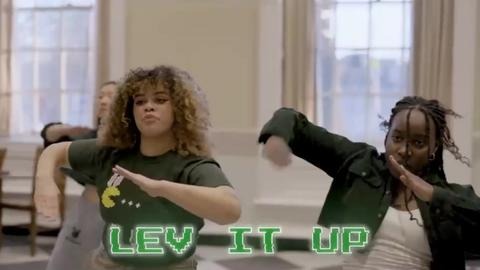 Still from Leverett House's 2025 Housing Day video with three students dancing in their dining hall.