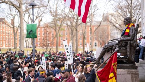 John Harvard statue surrounded by upperlevel students from each House on Housing Day prior to the dorm storm.