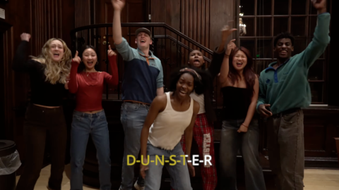 A snapshot of the Dunster House Housing Day video with seven students standing around rapping in the lobby of Dunster House.