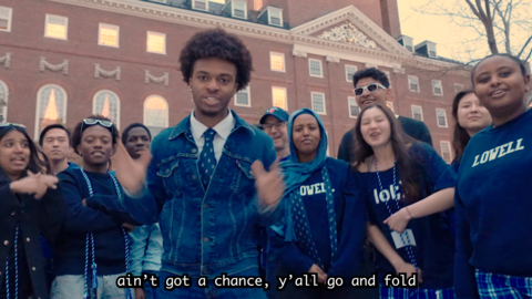 A snapshot of the Lowell House Housing Day video with students standing outside in the Lowell House courtyard.