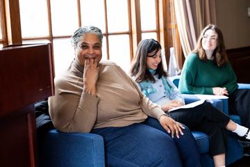 Dr. Roxanne Gay engaging in conversation with students during a leadership seminar.