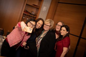 A student poses with four speakers for a selfie during a 2025 Women's Week speaker program.