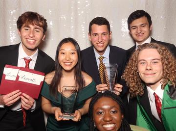 Leverrett House poses with their two Johnnie awards  in the photo booth during the 2025 Housing Day video award ceremony.