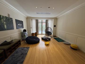 The Winthrop House meditation room with rugs, soft seating, and tranquil paintings.