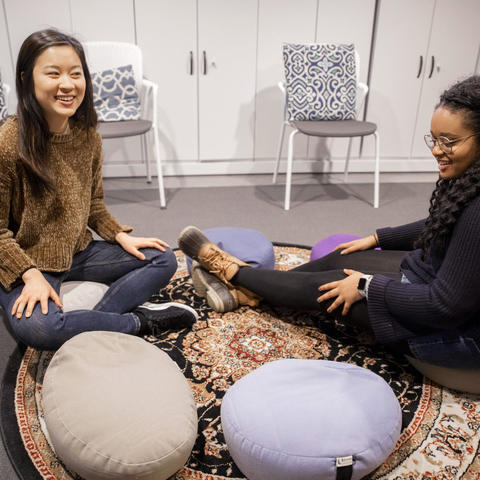 Two students sitting on the floor