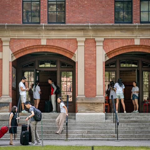 Students outside of first-year dorms in the Yard during first-year move-in.