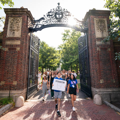 First-year students from Stoughton leaving Harvard Yard led by their Peer Advising Fellows through Johnston Gate.