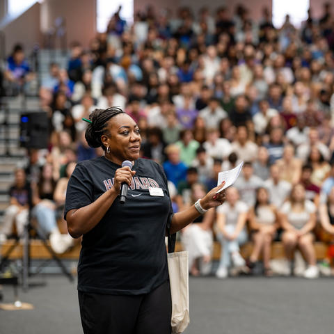 Dean Nekesa Straker walks in front of a crowd of first-year students during the orientation welcome. 