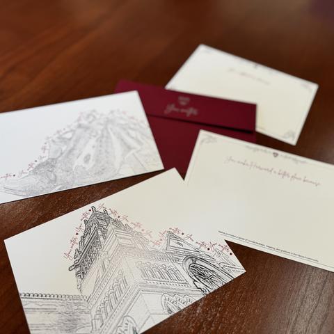 Mattering postcards of gratitude with Crimson envelopes laid out on a desk.