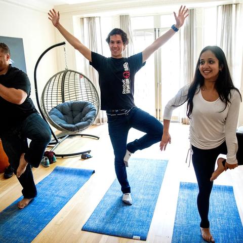 Students practicing yoga poses on yoga mats in the Winthrop House meditation room.