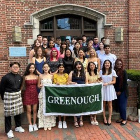 students outside their dorm holding a banner