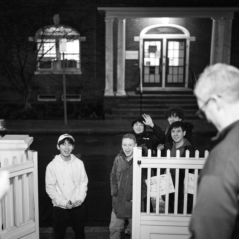 A group of students wave and greet Dean Tom Dunne at his residence on Housing Day Eve.