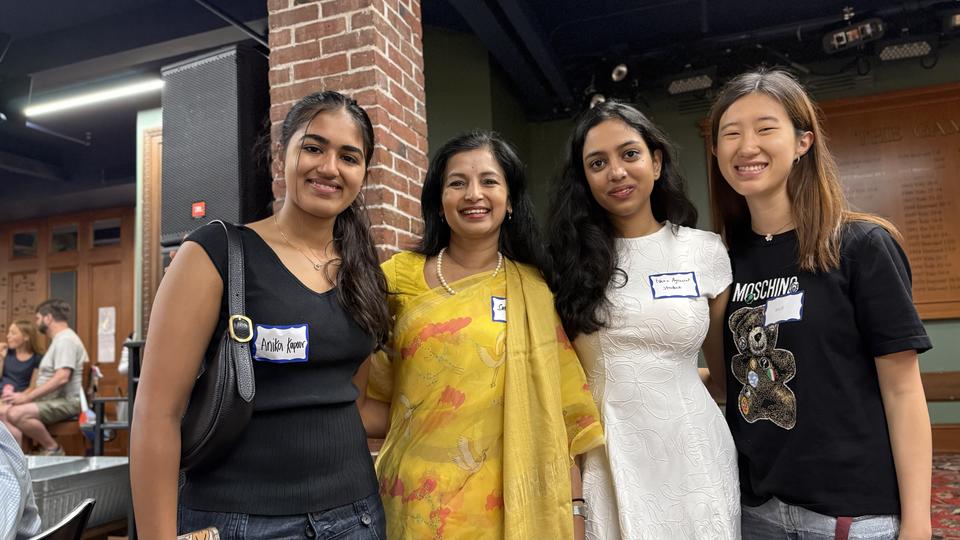 four women stand together smiling 