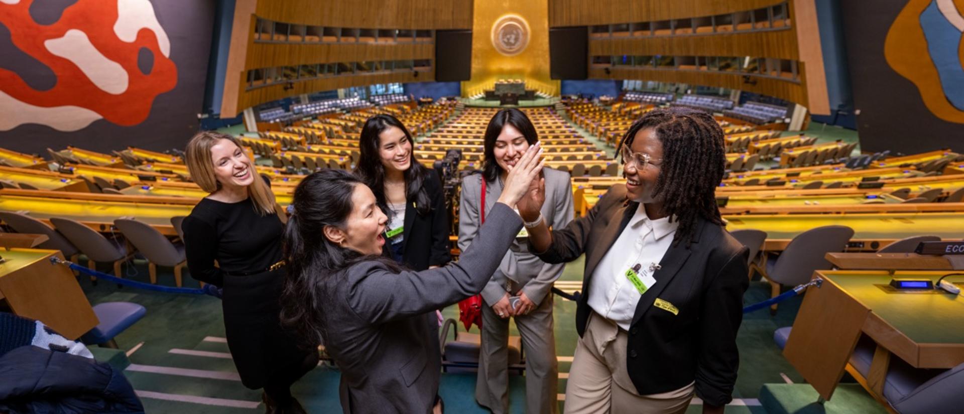Students and staff high-five each other during the UN Commission on the Status of Women.