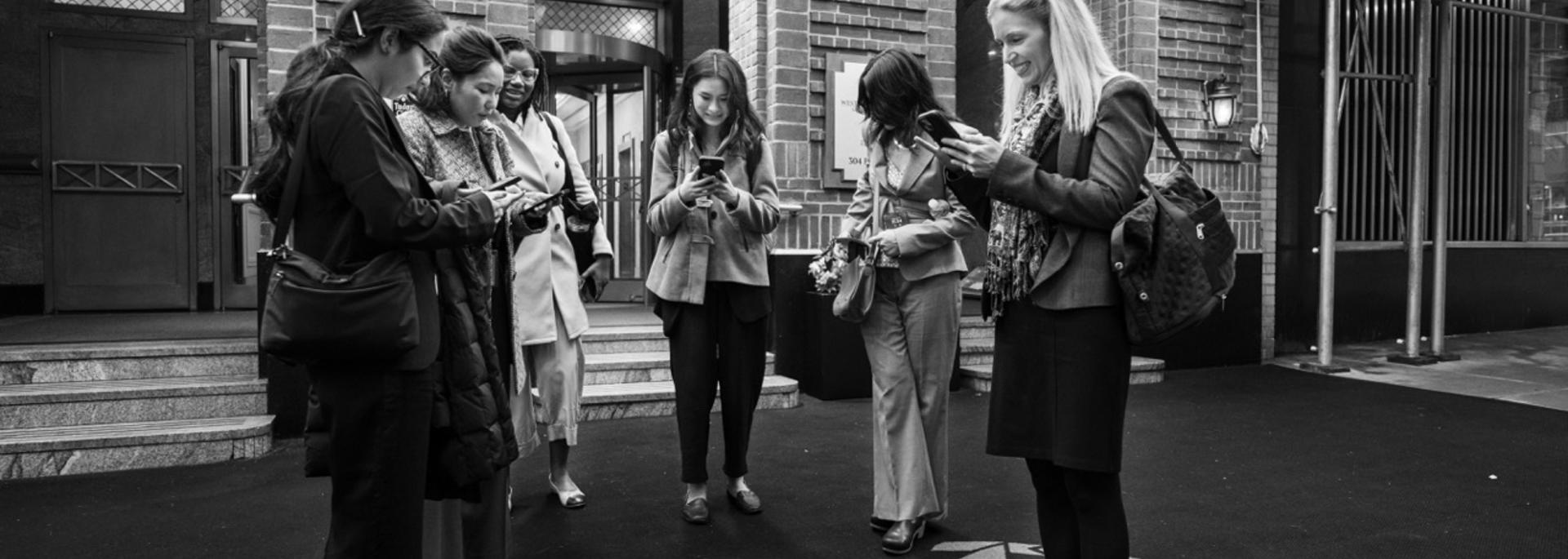 Students attending the United Nations Commission on the Concerns fo Women huddled together and checking their documents prior to entering a session.
