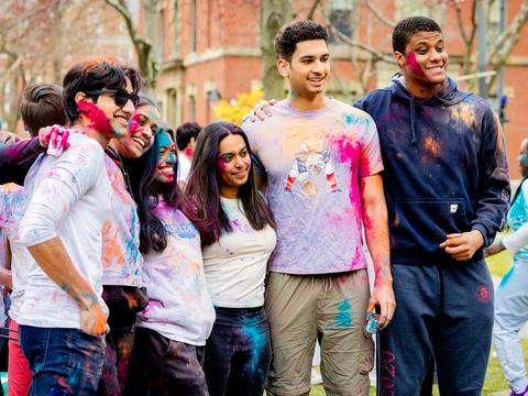 Students pose for a group photo with their arms around each other in the midst of the 2025 Holi celebration in the Yard.
