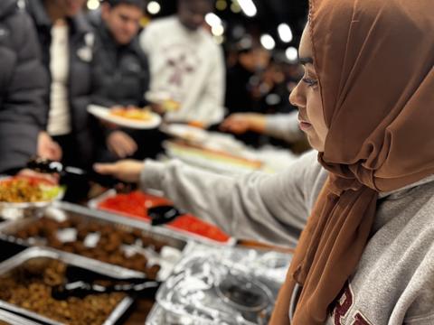 Harvard College student serving a meal to their peers during the DSO-sponsored iftar during Ramadan 2025.