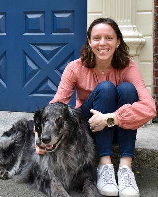Sarah sitting on the steps with her dog at Lowell House.