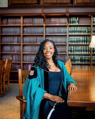 Valencia in graduation gown in a library
